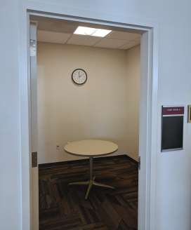 Small, round table and clock on wall in study room