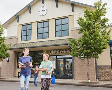 Children walking away from Battle Ground Community Library with books in hand