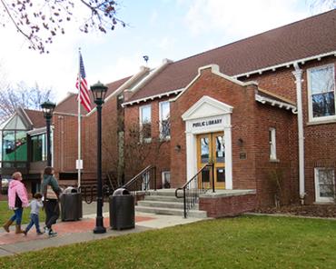 Two adults lead a child by the hand to the entrance of Goldendale Community Library