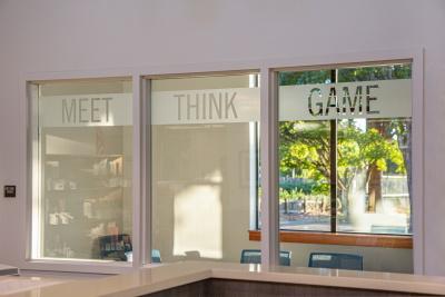 View through interior windows into a small meeting room with an exterior window