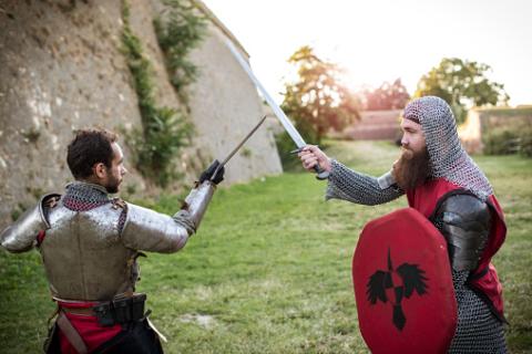 Two people sword fighting