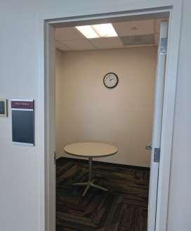 Small, round table and clock on wall in study room